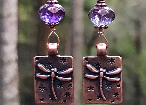 Wire wrapped copper dragonfly earrings with faceted purple Czechoslovakian crystals.